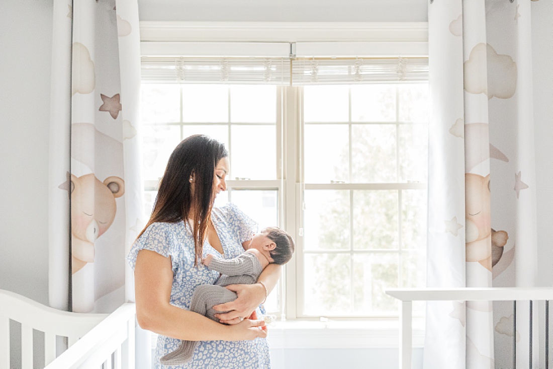 mom holds baby in nursery during in home newborn photography in Natick Massachusetts with Sara Sniderman Photography