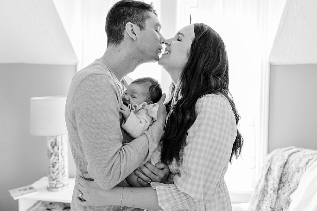 black and white photo of parents holding baby in home newborn photography metro west boston with Sara Sniderman Photography