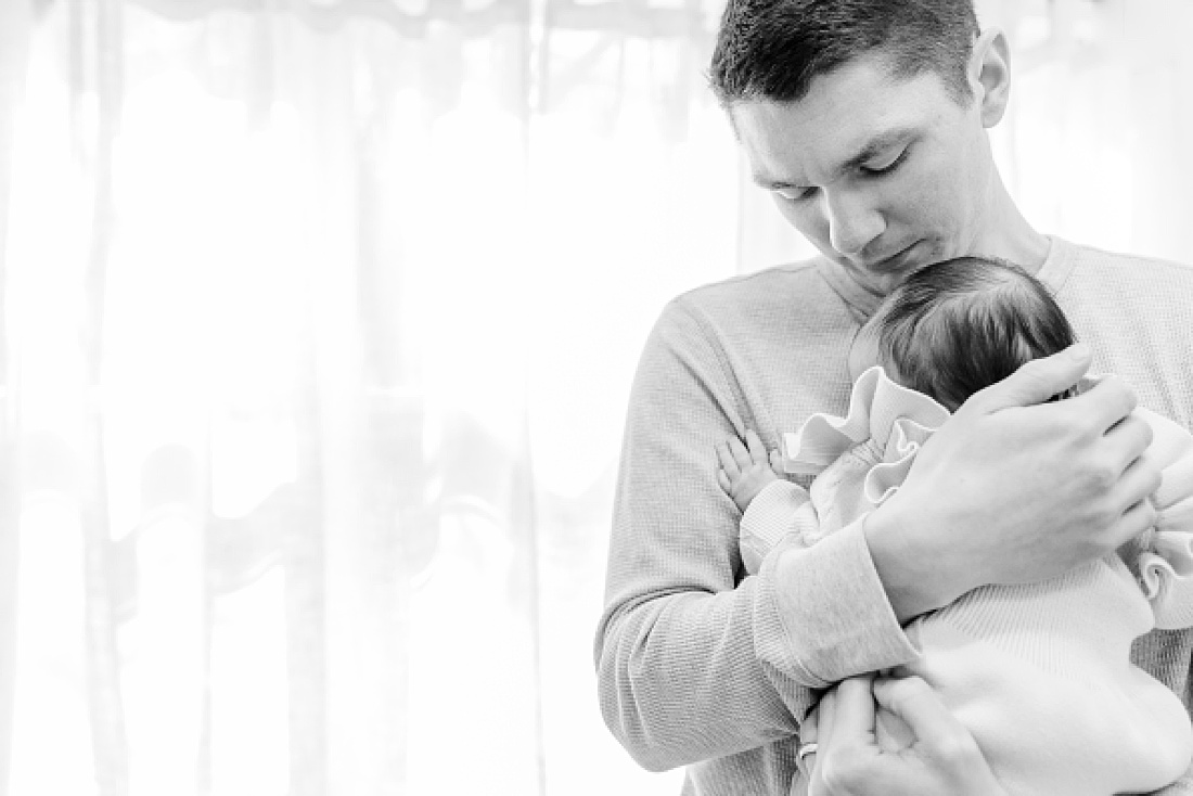 black and white of dad holding baby in home newborn photography metro west boston with Sara Sniderman Photography