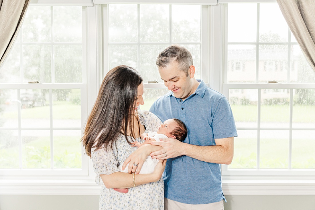 parents hold baby during In-home newborn photography in Metro West Boston with Sara Sniderman Photography