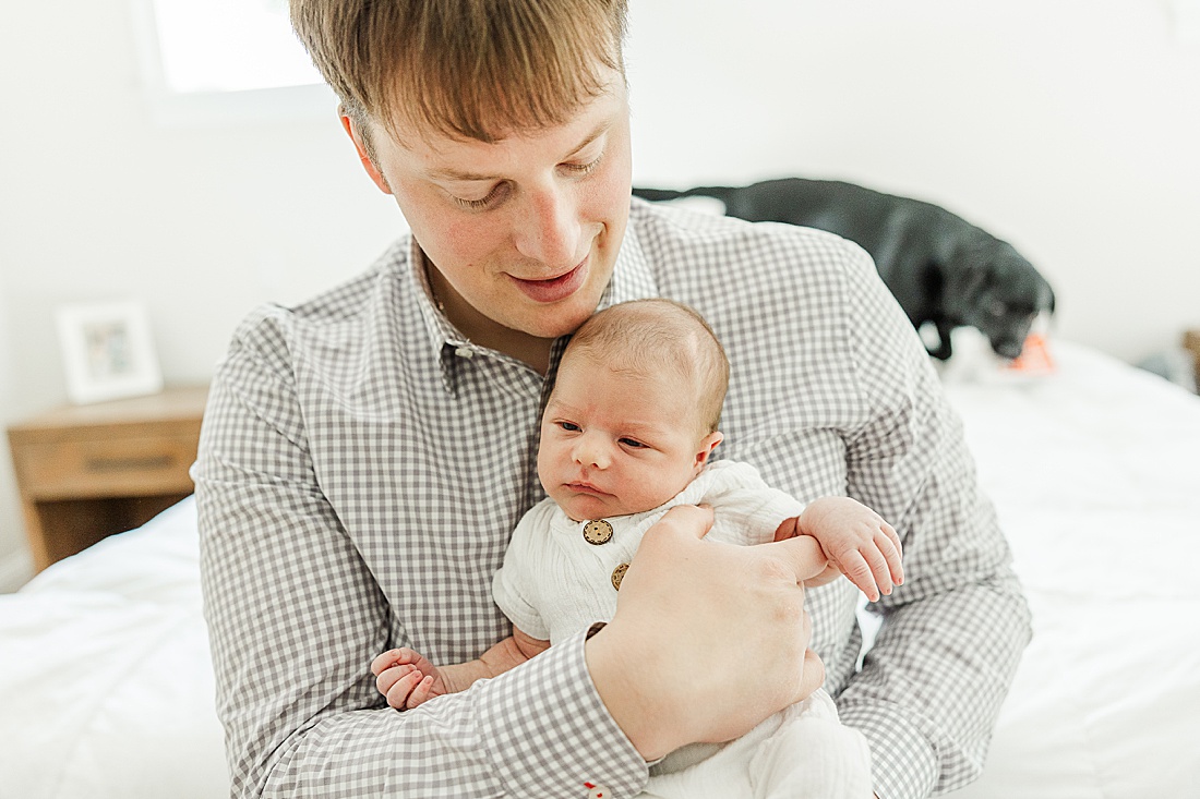 dad holds baby during in-home photo session in Millis Massachusetts with Sara Sniderman Photography