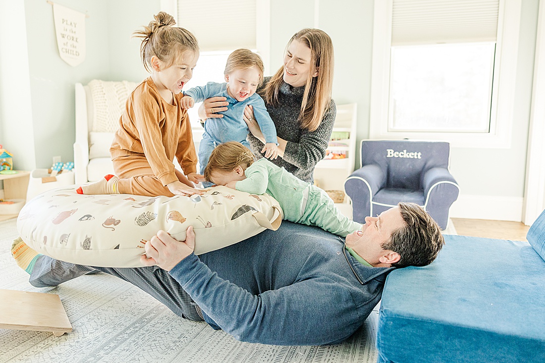 family plays on floor during in home family photo session with Sara Sniderman Photography in Metro West Boston