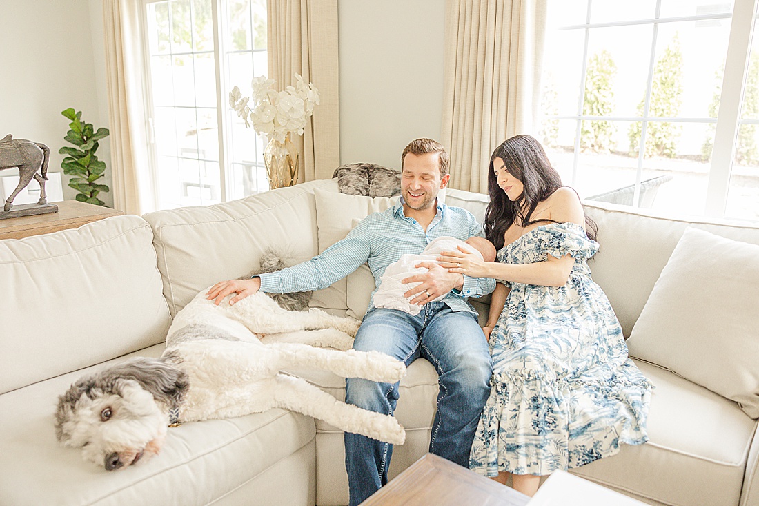 family sit on couch with dog during in home family photo session with Sara Sniderman Photography in Metro West Boston