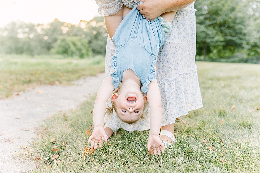 Image of professional family photo session taken by Sara Sniderman Photography, a family, newborn and maternity photographer serving the Metro West Boston area include: Natick, Needham, Newton, Wellesley, Wayland, Weston, Sherborn, Sudbury, Southborough, Medfield, Medway, Holliston, Framingham. The image is of girl held upside down