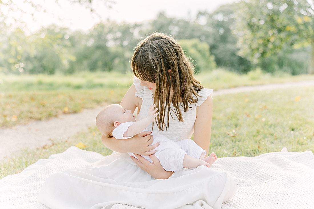 Image of professional family photo session taken by Sara Sniderman Photography, a family, newborn and maternity photographer serving the Metro West Boston area include: Natick, Needham, Newton, Wellesley, Wayland, Weston, Sherborn, Sudbury, Southborough, Medfield, Medway, Holliston, Framingham. The image is of a sister holding her baby sister. 