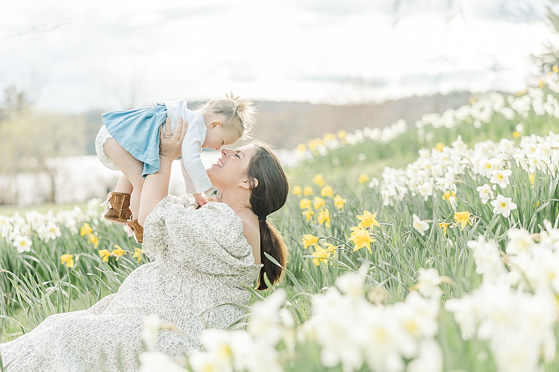 Image of professional family photo session taken by Sara Sniderman Photography, a family, newborn and maternity photographer serving the Metro West Boston area include: Natick, Needham, Newton, Wellesley, Wayland, Weston, Sherborn, Sudbury, Southborough, Medfield, Medway, Holliston, Framingham. The image is of mother and daughter in field of daphodils