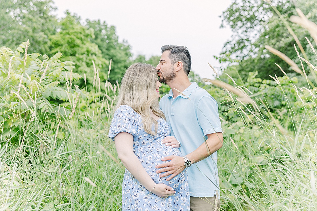 Image of professional maternity and newborn photo session taken by Sara Sniderman Photography, a family, newborn and maternity photographer serving the Metro West Boston area include: Natick, Needham, Newton, Wellesley, Wayland, Weston, Sherborn, Sudbury, Southborough, Medfield, Medway, Holliston, Framingham. The image is of husband kissing wifes head