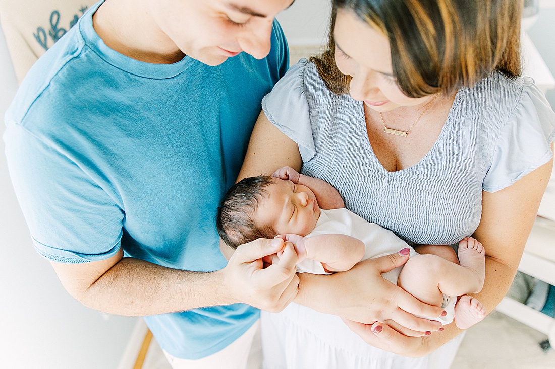 Image of professional newborn photos taken by Sara Sniderman Photography, a family, newborn and maternity photographer serving the Metro West Boston area include: Natick, Needham, Newton, Wellesley, Wayland, Weston, Sherborn, Sudbury, Southborough, Medfield, Medway, Holliston, Framingham. Image shows parents holding a baby. 