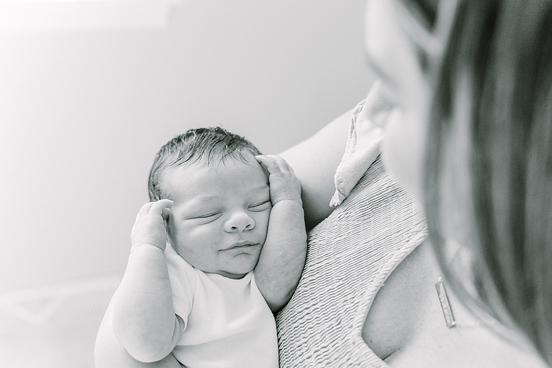 Image of professional newborn photos taken by Sara Sniderman Photography, a family, newborn and maternity photographer serving the Metro West Boston area include: Natick, Needham, Newton, Wellesley, Wayland, Weston, Sherborn, Sudbury, Southborough, Medfield, Medway, Holliston, Framingham. Image shows black and white photo of mom holding smiling baby. 