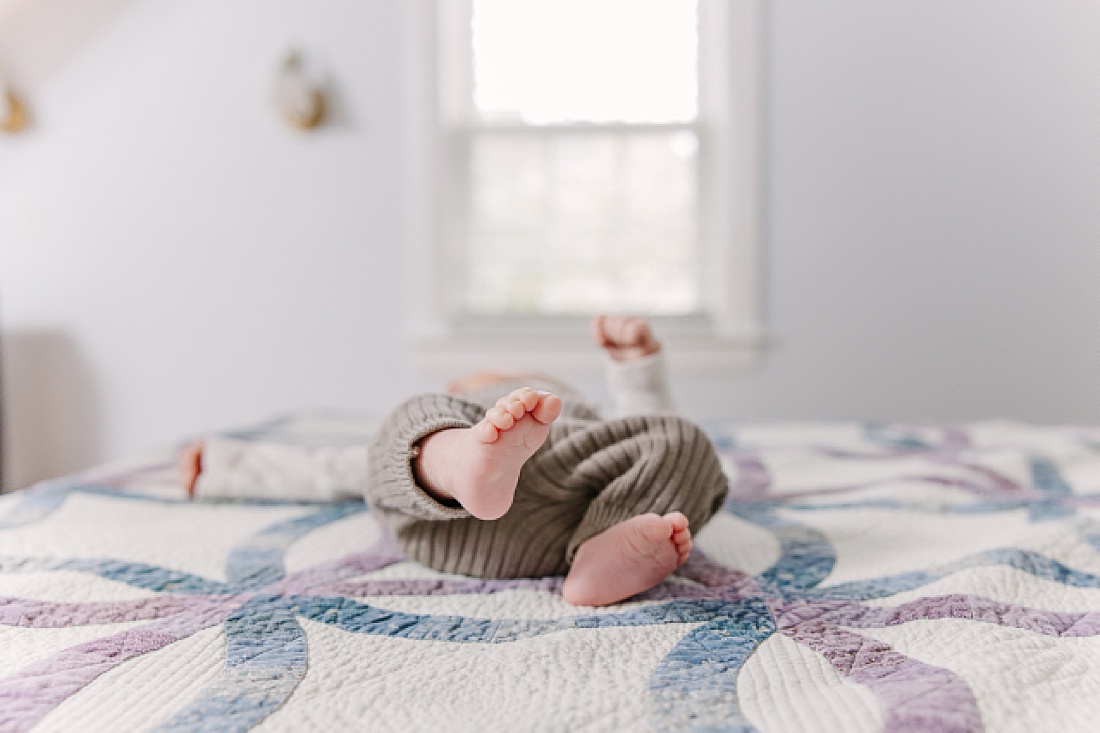 baby feet on bed during in home newborn photo session with Sara Sniderman Photography in Natick Massachusetts