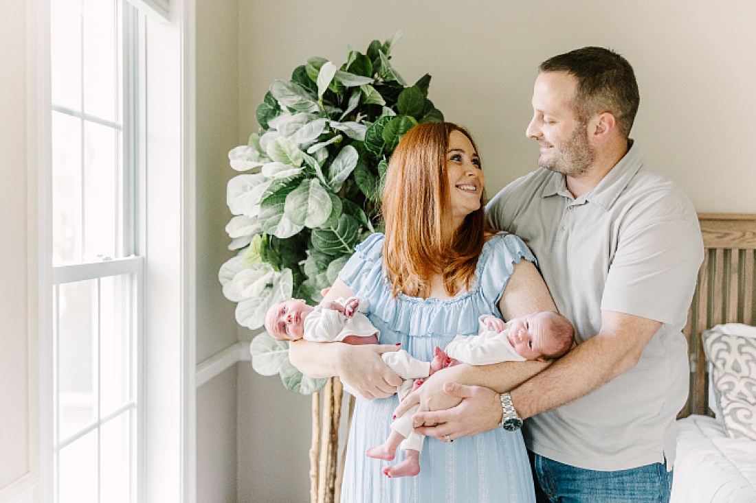 parents hold babies during twin newborn photo session in Natick Massachusetts with Sara Sniderman Photography