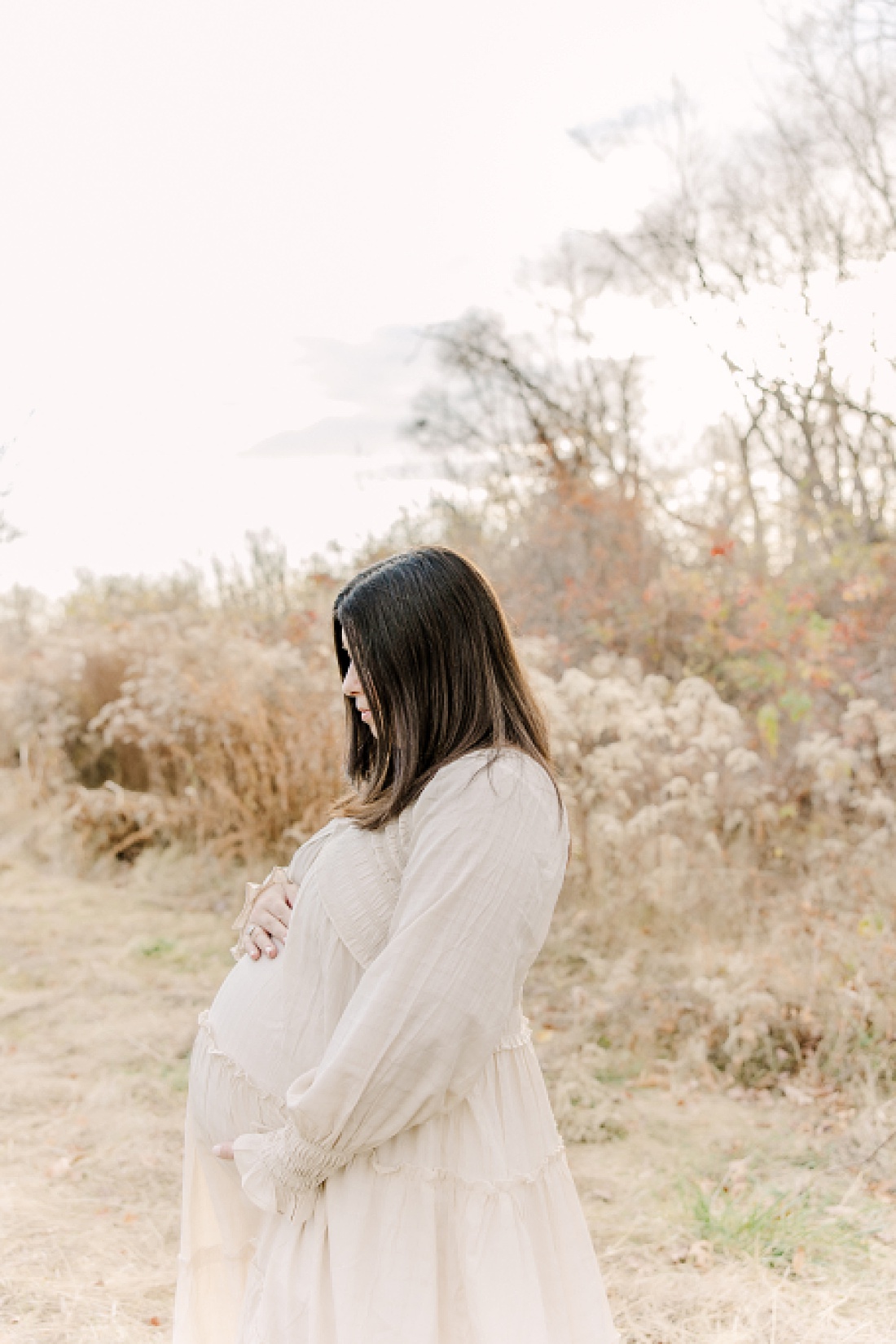 woman in field during maternity photo session with Sara Sniderman Photography in Needham Massachusetts