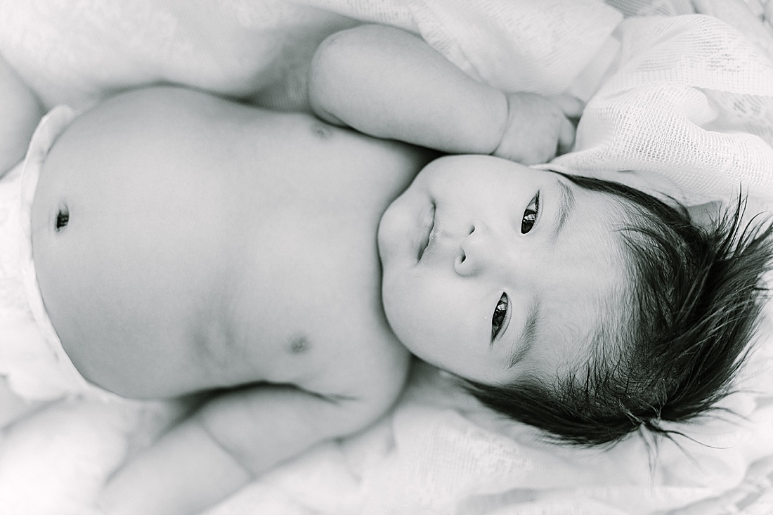 black and white of baby on bed during studio lifestyle photo session with Sara Sniderman Photography in Natick Massachusetts