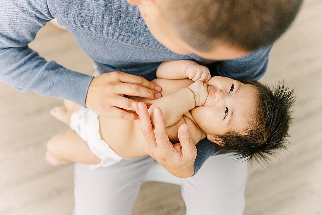 dad holds baby during studio lifestyle photo session with Sara Sniderman Photography in Natick Massachusetts