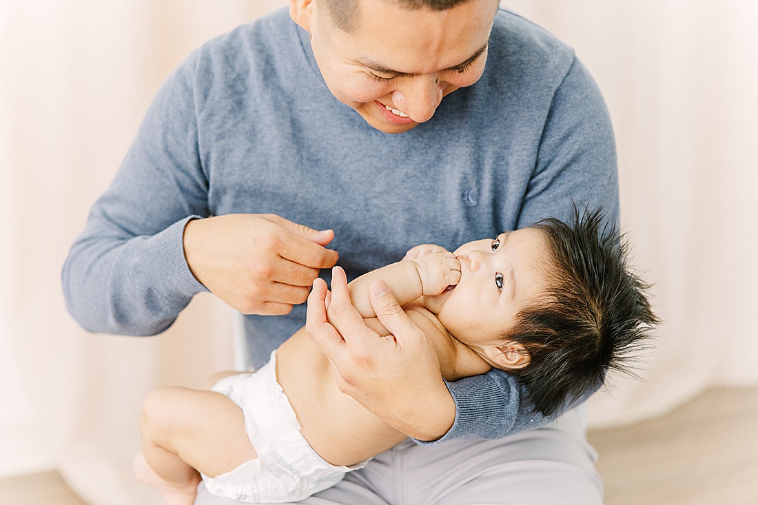 dad holds baby during studio lifestyle photo session with Sara Sniderman Photography in Natick Massachusetts