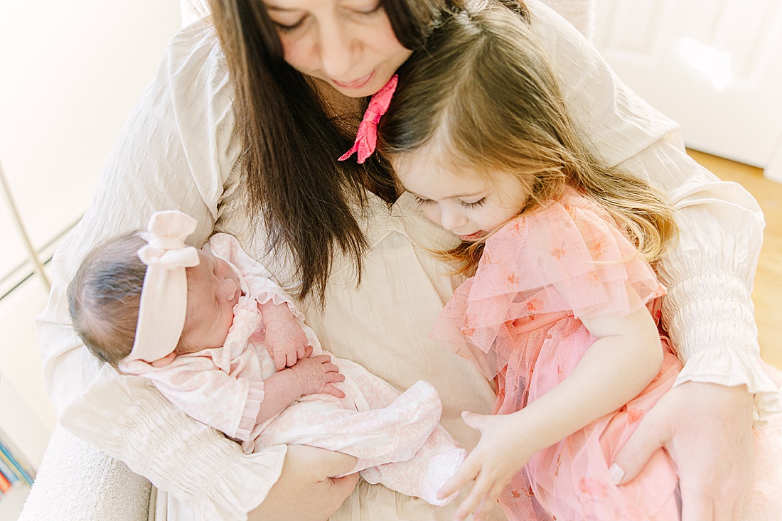 mom holds todder and baby during in-home newborn photo session with Sara Sniderman Photography in Needham Massachusetts