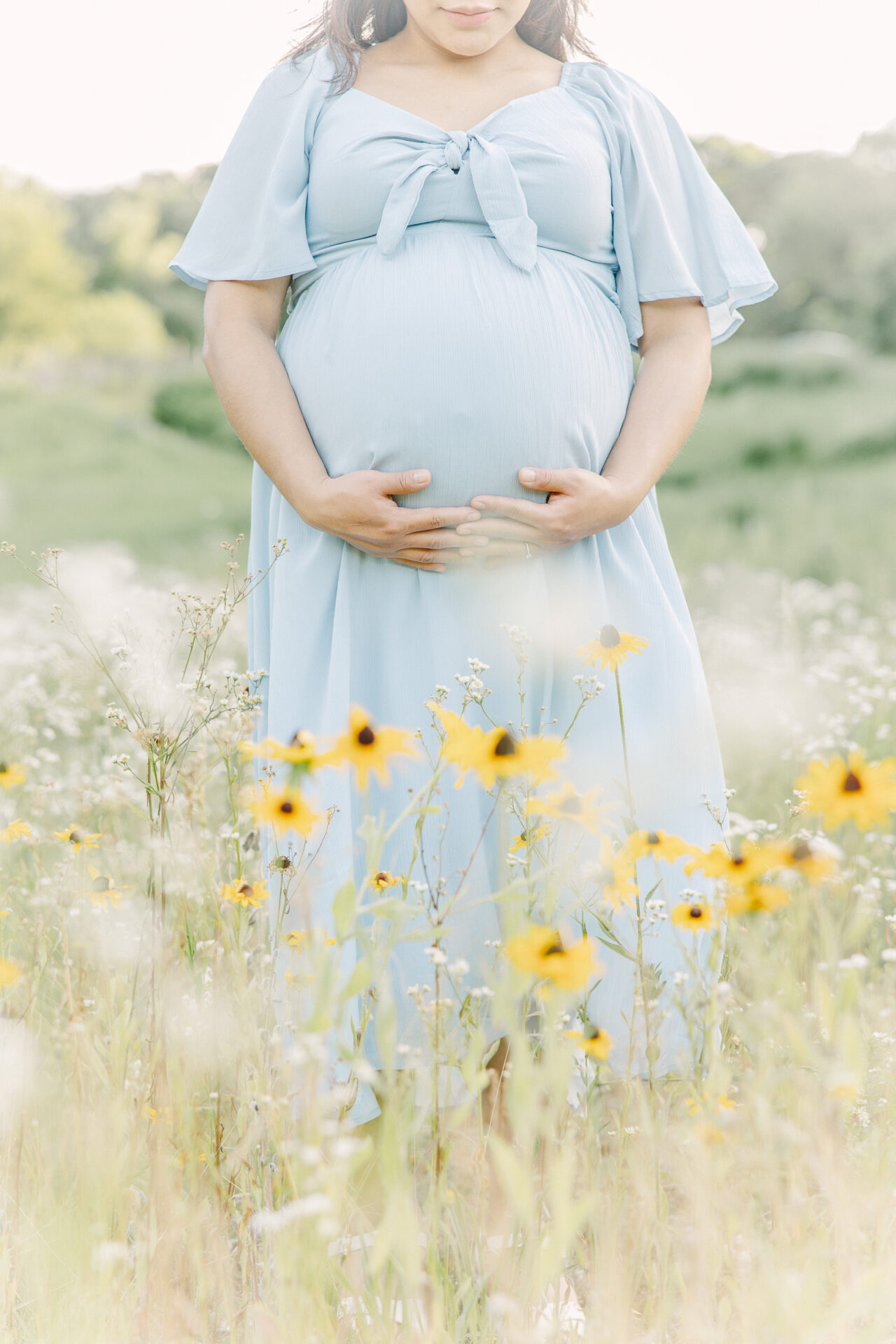 pregnant belly in field of flowers during maternity photo session with Sara Sniderman Photography in Newton Massachusetts