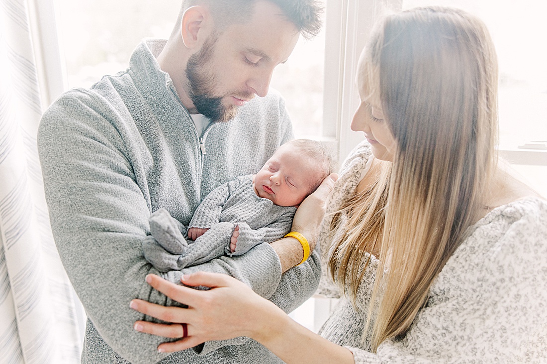 parents hold baby during in-home newborn photos with Sara Sniderman Photography in MetroWest Boston Massachusetts