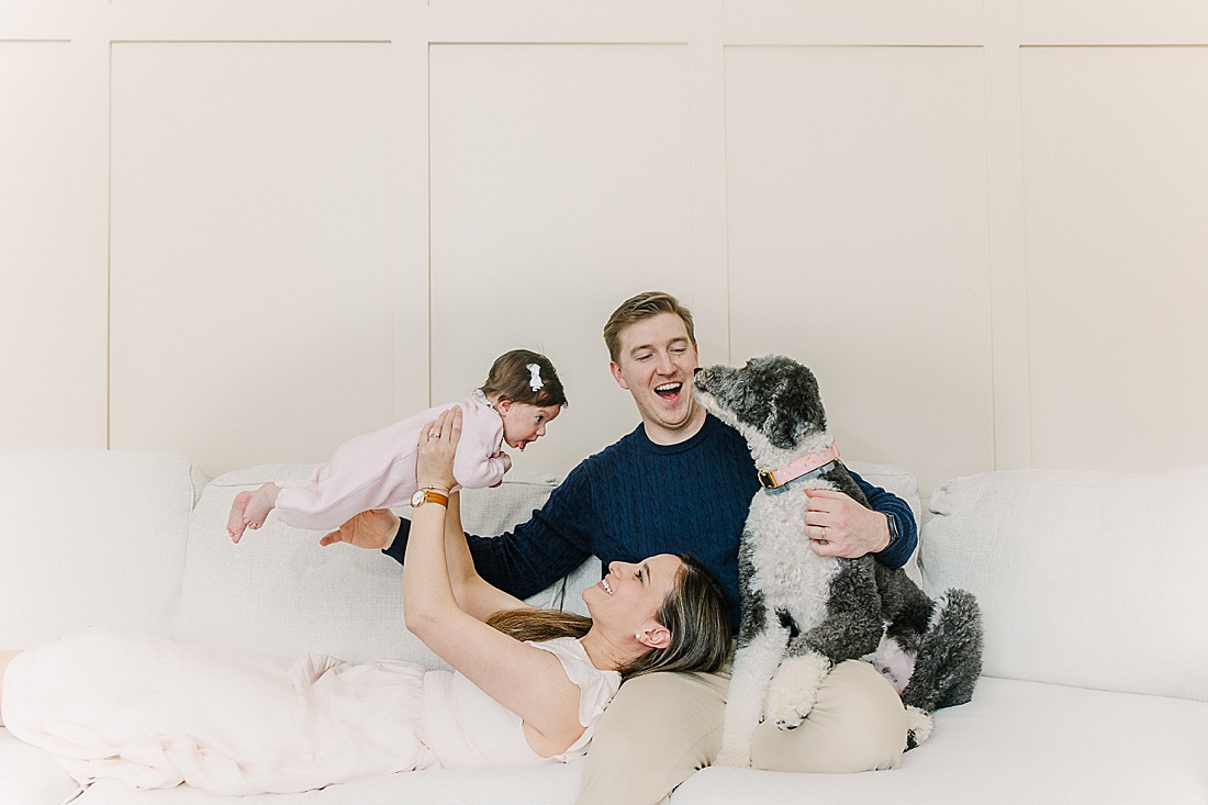 family lays on couch during in-home newborn photo session with Sara Sniderman Photography in Norwood Massachusetts