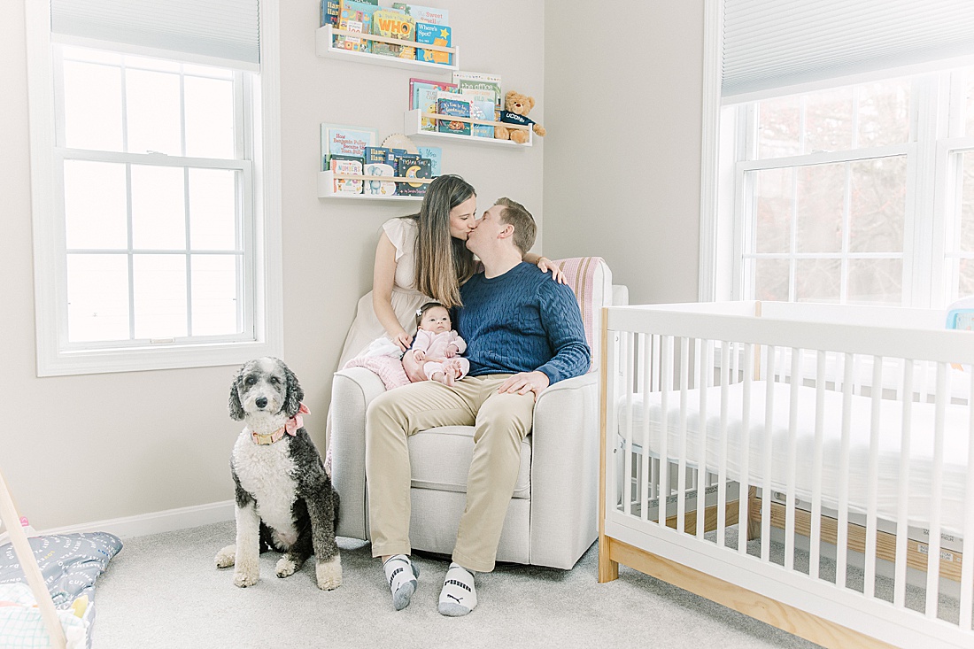 family cuddles in baby nursery during in-home newborn photo session with Sara Sniderman Photography in Norwood Massachusetts