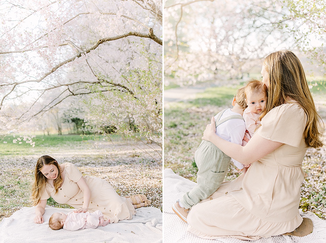 mother lays on blanket with baby below blooming tree uring family photo session with Sara Sniderman Photography at Wellesley College.