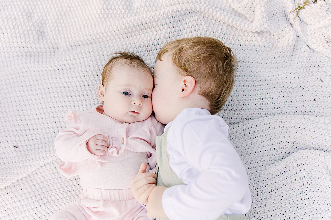 toddler kisses baby uring family photo session with Sara Sniderman Photography at Wellesley College.