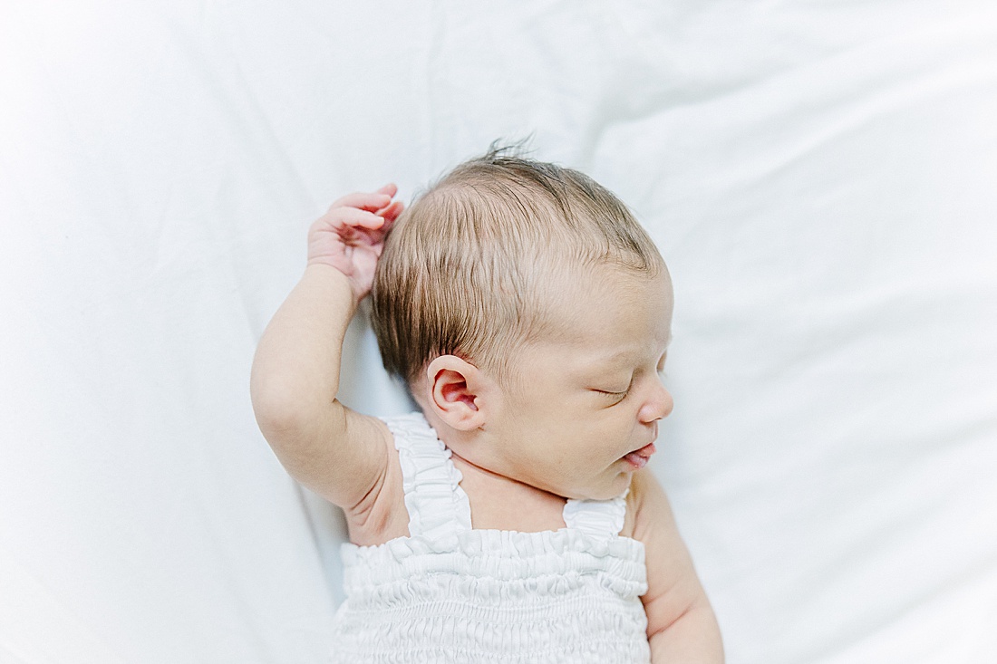 baby lays on bed during in-home newborn photo session with Sara Sniderman Photography in Natick Massachusetts