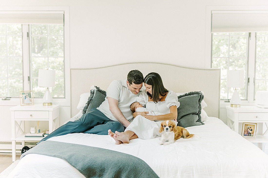 family snuggles on bed during in-home newborn photo session with Sara Sniderman Photography in Natick Massachusetts