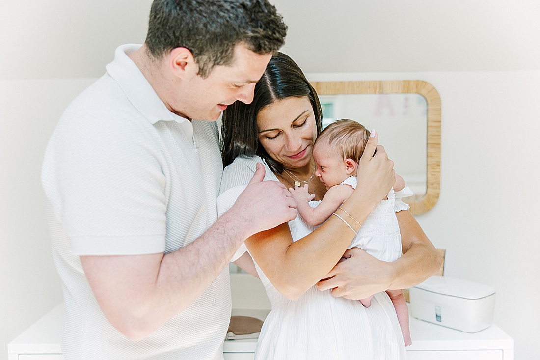 parents hold baby during in-home newborn photo session with Sara Sniderman Photography in Natick Massachusetts