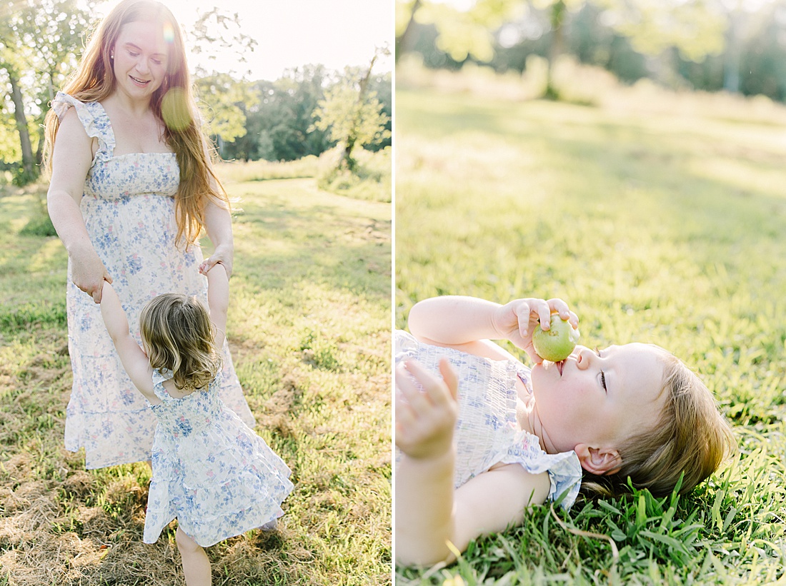 girl lays on ground eating apple during summer family photos with Sara Sniderman Photography t Heard Farm in Wayland Massachusetts. 