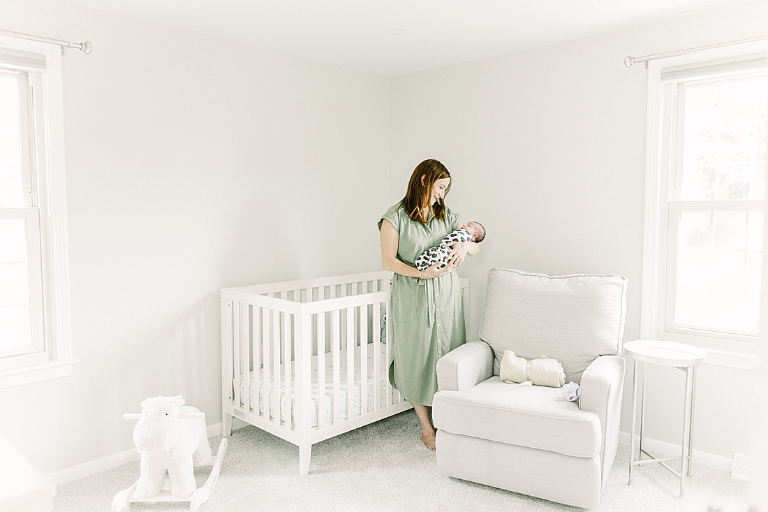 mother holds baby in nursery during in-home newborn photo session with Sara Sniderman Photography in Sherborn Massachusetts