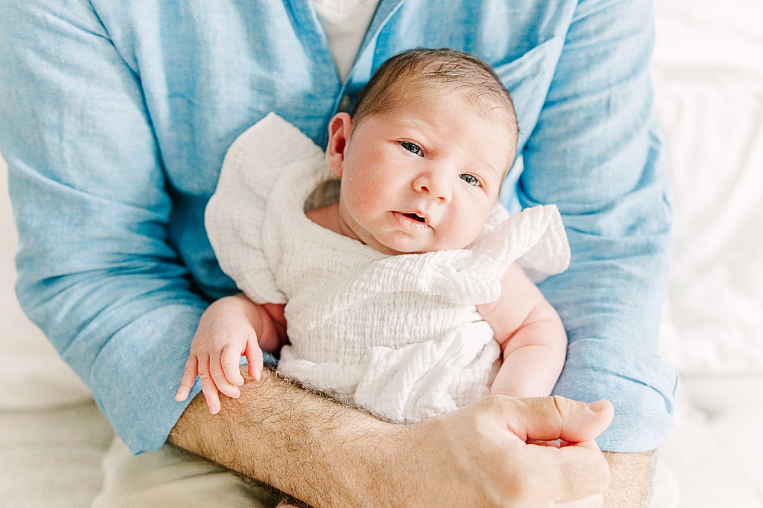 father holds baby during in-home newborn photo session with Sara Sniderman Photography in Sherborn Massachusetts