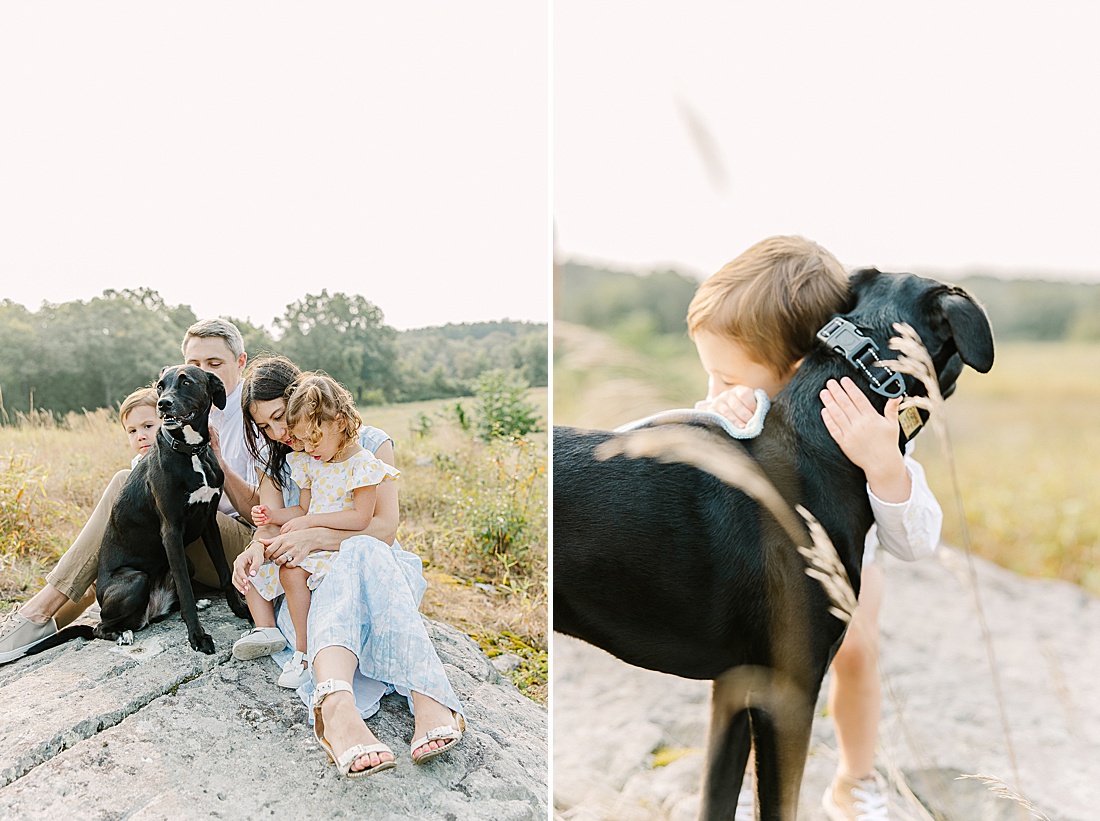 family and dog cuddle on a rock during family photo session with Sara Sniderman Photography in Needham Massachusetts