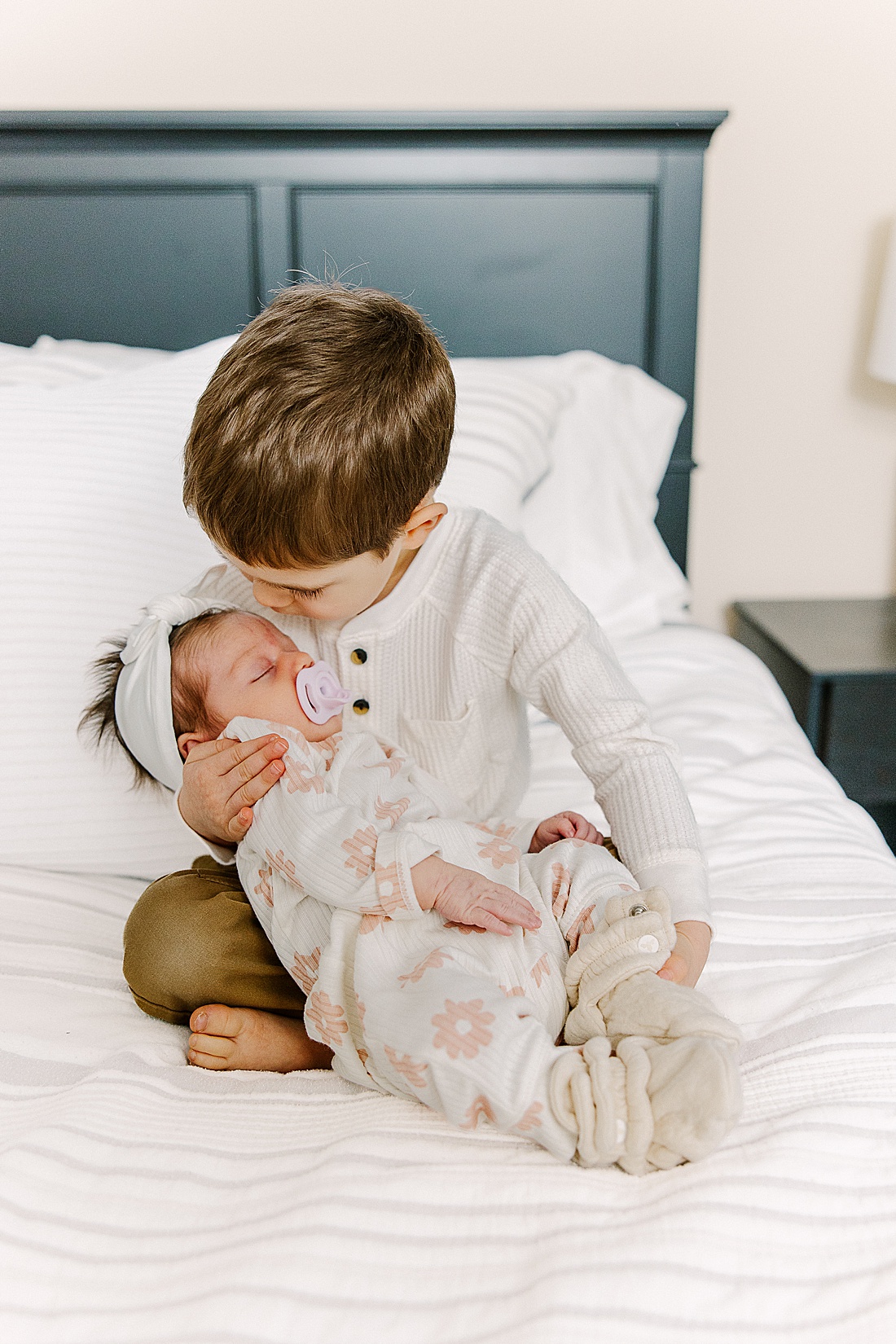 big brother holds baby sister during in-home newborn photo session with Sara Sniderman Photography in Natick Massachusetts