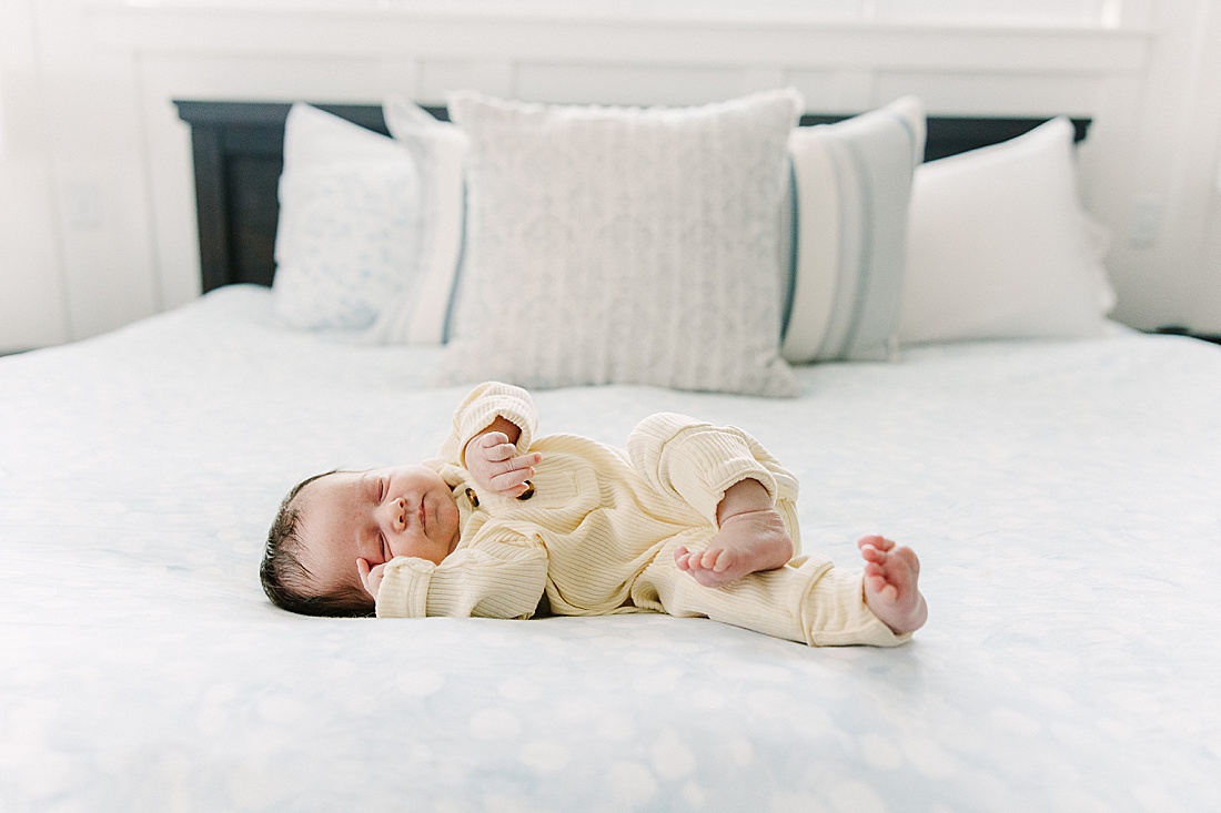baby lays on bed during in home newborn photo session with Sara Sniderman Photography in Holliston Massachusetts