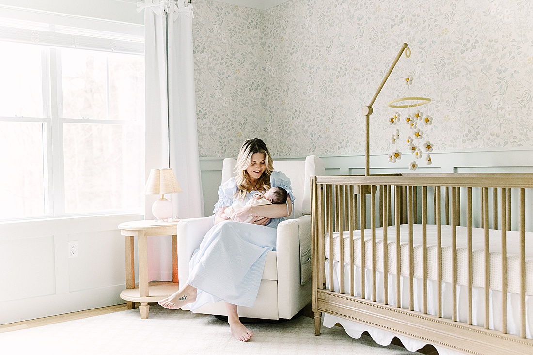 mother rocks baby during in home newborn photo session with Sara Sniderman Photography in Holliston Massachusetts